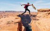 man jumping on rock formation